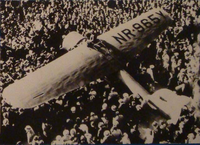 Amelia Earharts Lockheed Electra inmitten der Menschenmenge in Oakland, nachdem sie als erste Pilotin einen Soloflug von Hawaii aufs Festland der USA erfolgreich absolviert hatte. (Start 2. Januar 1935, Ankunft in Oakland 18 Stunden und 16 Minuten später)